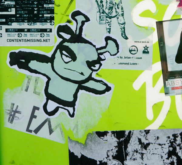 Graffiti art of a small green figure with horns looking angry
