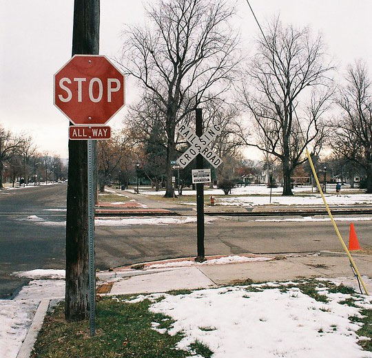 A Stop sign at a railroad crossing, in the snow with no traffic or people