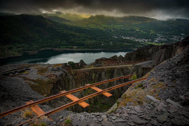 Train tracks extending out over empty space above a deep valley