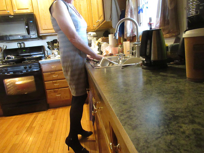 A woman doing dishes at the sink.