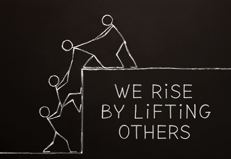 We rise by lifting others: drawing of stick figures helping one another up a cliff