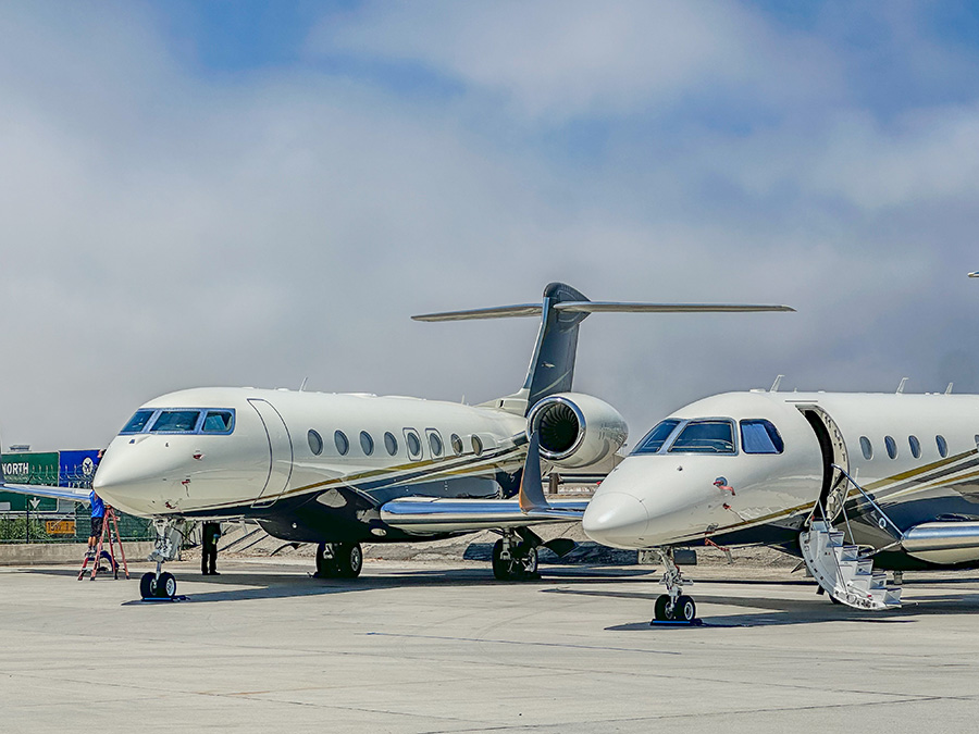 Two private jets parked on a runway.