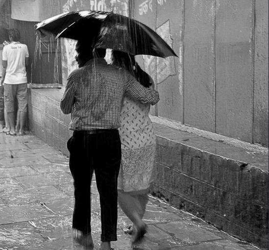 A couple sharing an umbrella